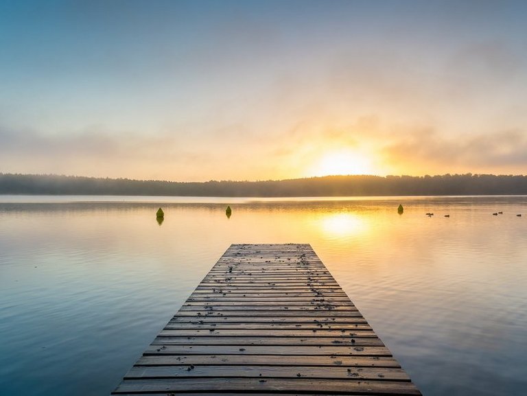 naturbild-seestimmung mit steg-sonnenspiegelung auf dem wasser